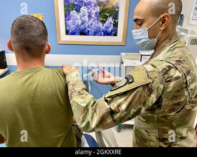 Sgt. Jonathan Harris, 3e Bataillon, 353e Régiment d'infanterie, vaccine le Cpl lance. Mason Brennan, 1er Bataillon, 23e Régiment de Marine à la clinique du foyer médical du Centre de soldat lors de son évaluation de santé périodique annuelle au Centre d'entraînement à la préparation interarmées et à fort Polk, en Louisiane, le 22 juillet. Banque D'Images