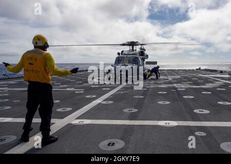 210726-N-QR052-1060 OCÉAN PACIFIQUE (JUILLET 26, 2021) le compagnon de Boatswain de 2e classe David Miller, de Chicago, dans l'Illinois. Signale aux marins de caler et de chaîner un Hawk de mer MH-60S affecté aux caractères génériques de l'Escadron de combat de la mer (HSC) 23 sur le pont de vol à bord du navire de combat littoral version Independence USS Jackson (LCS 6). Jackson effectue des opérations de routine dans la zone d'exploitation de la 3e flotte des États-Unis. Banque D'Images