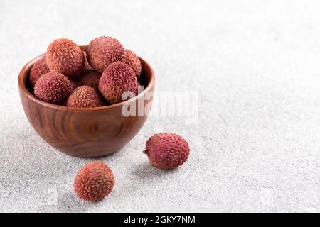 Fruit bien mûr dans un bol en bois sur fond de pierre grise avec espace de copie Banque D'Images