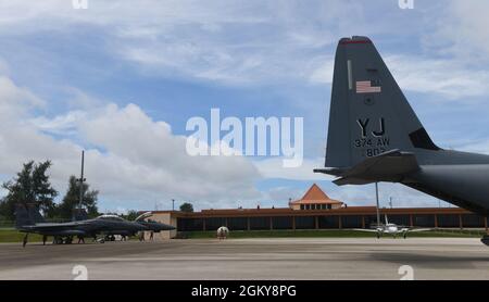 Deux pygargues de la US Air Force F-15E Strike à partir de la base aérienne de Mountain Home, Idaho, sont garés à l'aéroport international de Tinian, Tinian, le 27 juillet 2021, près d'un C-130J Super Hercules de la base aérienne de Yokota, au Japon. Des membres de la 366e Escadre Fighter sont arrivés sur Tinian pour une première fois historique afin de soutenir Pacific Iron 2021. Environ 800 aviateurs et 35 avions participent à l’opération d’emploi dynamique des forces aériennes du Pacifique du 11 juillet au 8 août 2021 à Guam et à Tinian pour projeter des forces dans la zone de responsabilité du Commandement Indo-Pacifique des États-Unis à l’appui de la Défense nationale de 2018 Banque D'Images