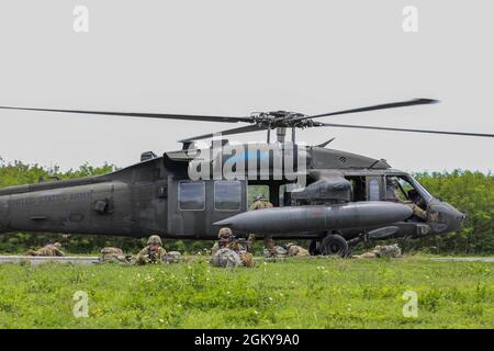 Les soldats participant au Forager 21 déchargent un FAUCON noir UH-60L et tirent la sécurité après avoir touché le nord de l'île Mariana, Tinian, le 27 juillet 2021 pour l'entraînement. Forager 21 est conçu pour tester et affiner les capacités des unités de soutien dans tous les domaines, la terre, l'air, la mer, l'espace et l'espace cybernétique de la région Indo-Pacifique. Banque D'Images