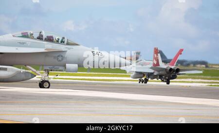 Un growler EA-18G de la Marine américaine avec l'escadron d'attaque électronique (VAQ) 132 et un avion Hornet F/A-18C du corps des Marines avec l'escadron d'attaque de chasseurs maritimes (VMFA) 232 taxi la ligne de vol pendant le Pacific Iron 2021 à la base aérienne d'Andersen, Guam, le 27 juillet 2021. Pacific Iron 2021 se concentre sur le déploiement, l'exploitation et le maintien de forces provenant de bases dispersées plus petites dans la région Indo-Pacifique. Banque D'Images