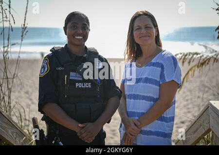 Christy Kalicharan (à gauche), officier de police du 45e Escadron des forces de sécurité et Gretta Lowry (à droite), Cocoa Beach (Floride), résident pose pour une photo de groupe à la base de la Patrick Space Force, en Floride, le 28 juillet 2021. Kalicharan a fourni une aide vitale à Lowry après avoir été mordu par un requin pendant le surf. Banque D'Images