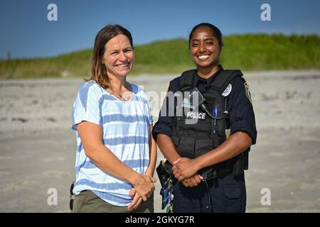 Christy Kalicharan (à droite), officier de police du 45e Escadron des forces de sécurité et Gretta Lowry (à gauche), Cocoa Beach (Floride), résident pose pour une photo de groupe à la base de la Patrick Space Force, en Floride, le 28 juillet 2021. Kalicharan a fourni une aide vitale à Lowry après avoir été mordu par un requin pendant le surf. Banque D'Images