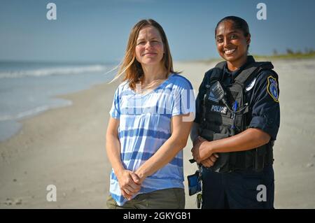 Christy Kalicharan (à droite), officier de police du 45e Escadron des forces de sécurité et Gretta Lowry (à gauche), Cocoa Beach (Floride), résident pose pour une photo de groupe à la base de la Patrick Space Force, en Floride, le 28 juillet 2021. Kalicharan a fourni une aide vitale à Lowry après avoir été mordu par un requin pendant le surf. Banque D'Images