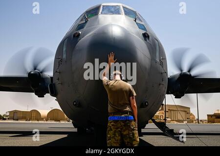 Un chef d'équipage de la Force aérienne des États-Unis, affecté au 40ème Escadron de transport aérien expéditionnaire, touche le nez d'un avion C-130J Super Hercules pour bonne chance avant d'embarquer dans l'avion pour une mission de soutien de la Force opérationnelle interarmées combinée - opération Resolve inhérente, Dans la zone de responsabilité du Commandement central des États-Unis, le 20 juillet 2021. La conception flexible du C-130 lui permet d'être configuré pour de multiples missions différentes, permettant à un avion de jouer le rôle de plusieurs et de projeter la première puissance aérienne de transport aérien dans l'AOR USCENTCOM. Banque D'Images