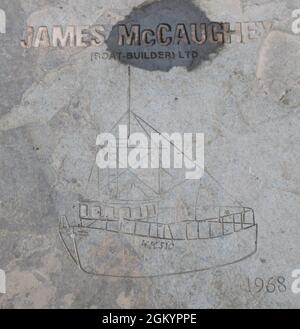 Wick, Écosse - les pierres de drapeaux d'affaires sur le trottoir - James McCaughey (Boat-Builder) Ltd, 1968. Banque D'Images