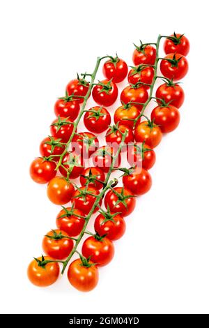 Vue de dessus image de plusieurs petits pains de tomates cerises mûres avec leurs branches vertes sur une table blanche Banque D'Images