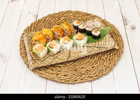 Plateau de sushis assorti avec nigiri de saumon, rouleau de californie uramaki, thon et avocat maki, algues nori, nouilles de riz, wasabi et ginseng Banque D'Images