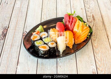 Assortiment de sushis avec maki farci de riz et d'avocat, nigiri de thon rouge, crevettes cuites, algues nori et babeurre, sashimi de saumon norvégien Banque D'Images