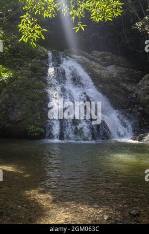 Magnifique plan vertical d'une chute d'eau tombant sur des rochers, puis dans un petit lac Banque D'Images