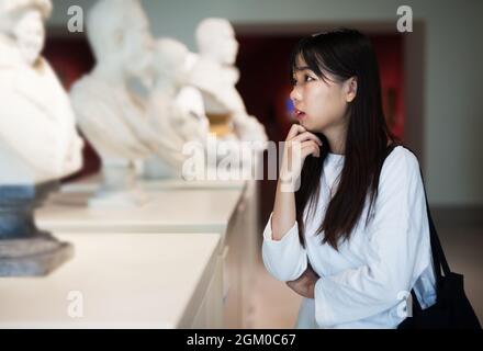 Fille chinoise à la recherche de sculptures dans le musée Banque D'Images