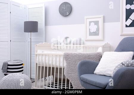Chambre bébé lit bébé blanc avec design et fauteuil Photo Stock - Alamy