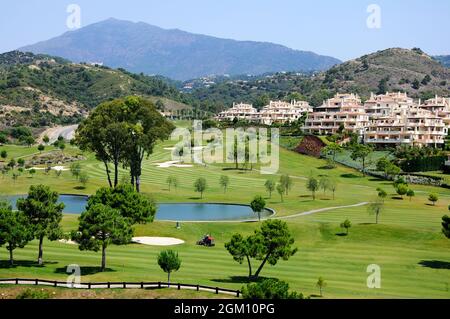 Vue sur le parcours de golf El Higueral avec appartements et montagnes à l'arrière, Benahavis, Espagne. Banque D'Images