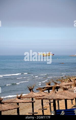 Bombardier de feu recueillant de l'eau de la mer pour s'attaquer aux feux de brousse, Calahonda, Espagne. Banque D'Images