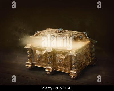 Boîte ouverte dorée avec lumière sur fond sombre Banque D'Images