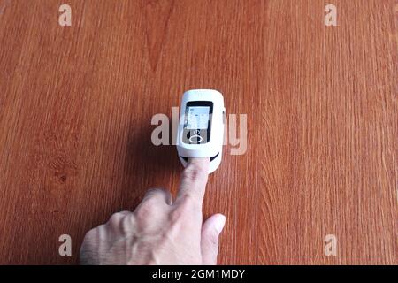 Sélection de l'image de mise au point du doigt à l'aide de l'oxymètre de pouls sur une table en bois. Concept médical et de soins de santé Banque D'Images