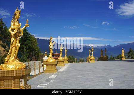 Des statues élégantes de la déesse dorée bordent la terrasse supérieure autour de la statue de Bouddha Dordenma dans le parc naturel de Kuensel Phodrang près de Thimphu, au Bhoutan. Banque D'Images