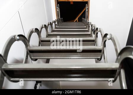 Escaliers métalliques cachés dans le plafond au grenier avec une trappe d'ouverture et des escaliers pliants dans le couloir, vue du bas de l'escalier vers le haut, plus moder Banque D'Images