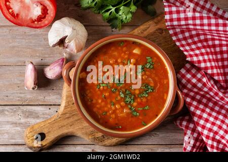 Soupe de lentilles rouges dans un bol sur une table en bois Banque D'Images