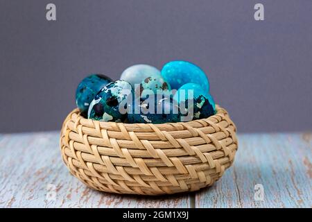 Œufs de caille bleu de Pâques dans un panier en osier. Banque D'Images