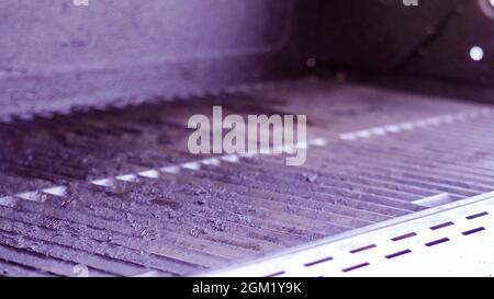 Vue rapprochée des grilles en fonte d'un gril à gaz extérieur. Banque D'Images