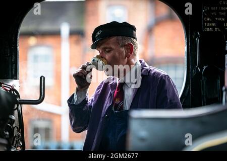 Kidderminster, Worcs, Royaume-Uni. 16 septembre 2021. Un chauffeur de train à vapeur est silhoueté dans son taxi car il a une tasse de thé dans sa canette avant d'embarquer pour une journée de voyage le jour d'ouverture du gala de vapeur d'automne du Severn Valley Railway, Kidderminster, Worcestershire. Le gala dure jusqu'au dimanche 19 septembre et comprend des lieux d'hôtes. Crédit : Peter Lophan/Alay Live News Banque D'Images