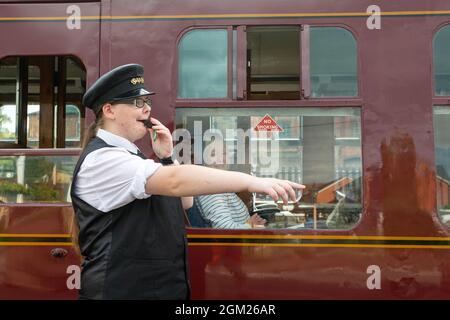 Kidderminster, Worcs, Royaume-Uni. 16 septembre 2021. Kaylie Armishaw, expéditrice bénévole de train à vapeur, lance un coup de sifflet alors qu'un train à vapeur embarque lors d'une journée de voyage le jour d'ouverture du gala de vapeur d'automne du Severn Valley Railway, Kidderminster, Worcestershire. Le gala dure jusqu'au dimanche 19 septembre et comprend des lieux d'hôtes. Crédit : Peter Lophan/Alay Live News Banque D'Images