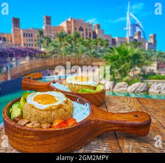 Le délicieux déjeuner sur la terrasse extérieure du restaurant à Souk Madinat Jumeirah, profitez de porridge d'amaranth, d'œufs frits, de légumes grillés et d'une vue sur Banque D'Images