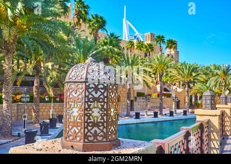 La ligne de belles lampes arabes le long de la rive du canal avec parc vert ombragé en arrière-plan, marché Souk Madinat Jumeirah, Dubaï, Émirats Arabes Unis Banque D'Images