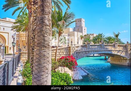 Le petit pont en pierre de l'autre côté du canal avec une vue sur Madinat Arena en arrière-plan, Souk Madinat Jumeirah Market Complex, Dubaï, Émirats Arabes Unis Banque D'Images