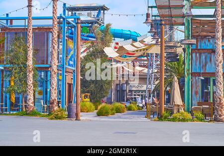 DUBAÏ, Émirats Arabes Unis - 4 MARS 2020 : les toboggans aquatiques du parc aquatique Laguna Waterpark sont visibles derrière les restaurants et les boutiques de la Mer Beachside shopping et restauration dist Banque D'Images