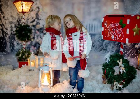 Mignons enfants blonds, garçons et filles, frères et sœurs, poster la lettre de Noël au Père Noël, jour d'hiver enneigé Banque D'Images