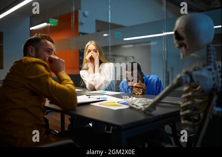 Les responsables effrayés et le squelette dans LE BUREAU INFORMATIQUE, blague Banque D'Images