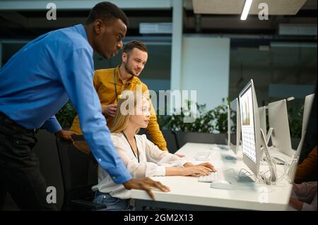 Une équipe de responsables regarde à l'écran dans le bureau INFORMATIQUE Banque D'Images