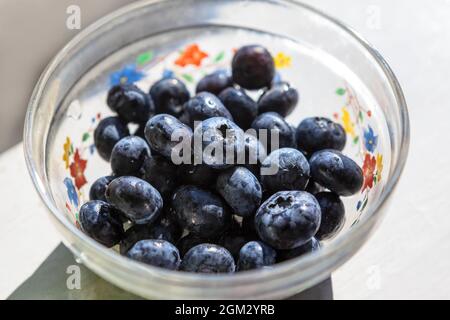 Bleuets dans le bol en verre . Baies saines pour le petit déjeuner Banque D'Images