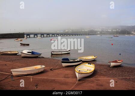 Des bateaux à rames ont été enrachés sur la plage de Teign à Shaldon avec le pont routier traversant la rivière jusqu'à Teignmouth sur la rive opposée. Banque D'Images