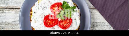 Bannière de gâteau de Zucchini avec tomates et persil frais sur fond de bois blanc. Vue de dessus avec serviette Banque D'Images