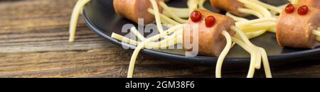 bannière de spaghetti avec saucisses sous forme d'araignées. Bonne nourriture pour enfants pour Halloween sur fond de bois. copyspace Banque D'Images