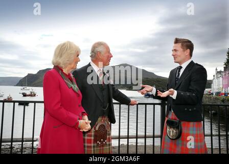 Robert Robertson, chanteur gaélique, parle au prince de Galles et à la duchesse de Cornouailles, connue sous le nom de duc et duchesse de Rothesay en Écosse, lors de leur visite à Portree, dans l'île de Skye, dans les Highlands d'Écosse, pour voir comment les entreprises vont de l'avant après le verrouillage du coronavirus. Date de la photo : jeudi 16 septembre 2021. Banque D'Images