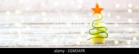 Bannière de l'arbre de noël créatif de concombre, fromage et étoile de carotte. Nourriture drôle pour enfants pour la fête du nouvel an sur fond gris avec espace de copie Banque D'Images