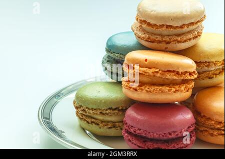 Assortiment de macarons colorés sur plaque sur fond blanc. Banque D'Images