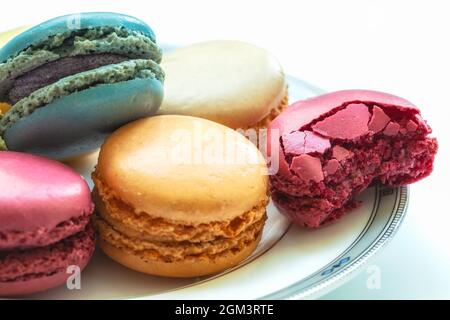 Assortiment de macarons colorés sur plaque sur fond blanc. Banque D'Images