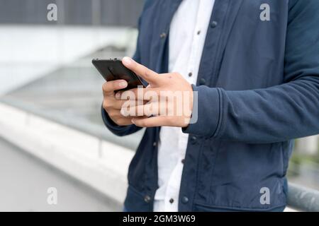 Gros plan Homme à envoyer des SMS sur un téléphone portable. Photo de haute qualité. Banque D'Images