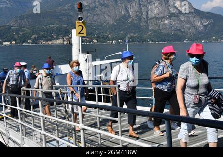 Les touristes portant des masques pandémiques Covid lorsqu'ils sortent du bateau sur le lac de Côme, Italie, province de Côme Banque D'Images