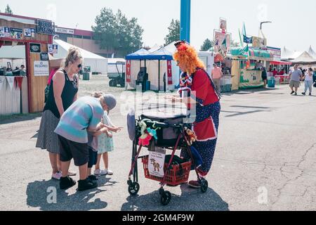 Boise, Idaho - 20 août 2021 : un clown donne à un enfant un animal de ballon à la Western Idaho State Fair Banque D'Images