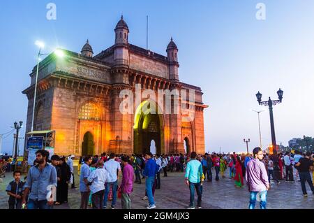 Mumbai, Maharashtra, Inde : les gens se rassemblent au crépuscule autour de la porte illuminée de l'Inde arche monumentale construite entre 1913 et 1924 dans l'Indo-Sara Banque D'Images