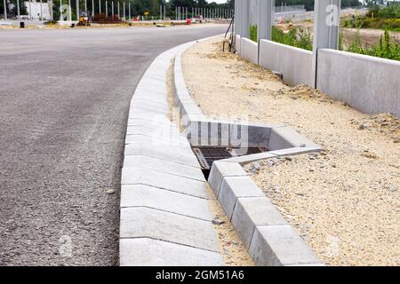 Un système de modules en béton pour vidanger l'excès d'eau de la surface de la route à l'aide d'une grille de vidange. Construction de l'autoroute. Banque D'Images