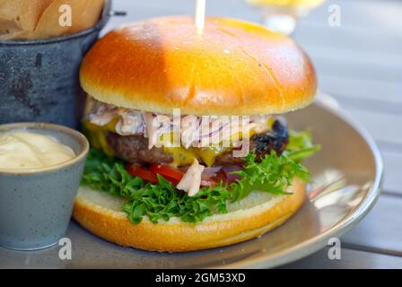 hamburger maison avec pommes de terre frites et souce sur table en bois Banque D'Images