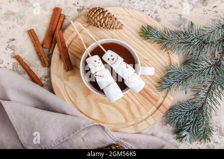 Bonshommes de neige en guimauves douces et une tasse de chocolat chaud sur fond de grunge Banque D'Images